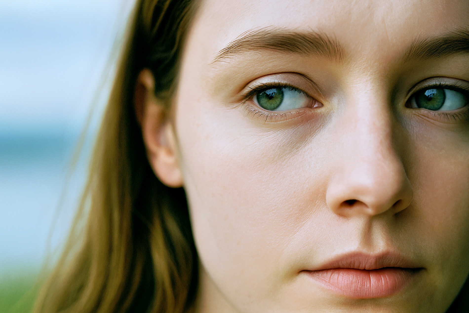 Nahaufnahme eines weiblichen Gesichts, das zur Seite blickt, mit Fokus auf das linke Auge