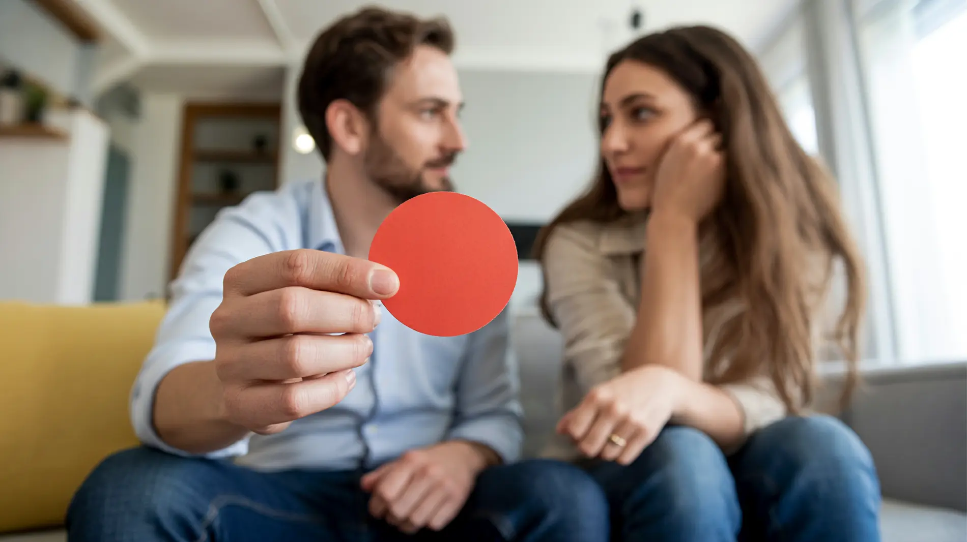 Ein Partner hält eine kleine rote kreisförmige Pappe hoch und zeigt sie dem anderen als Kommunikationssignal